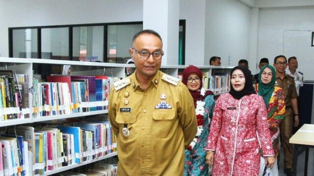 Subang, sebuah kabupaten yang terletak di provinsi Jawa Barat, baru saja menyaksikan sebuah langkah besar dalam dunia literasi. Pada Selasa, 3 Desember 2024, Gedung Layanan Perpustakaan Kabupaten Subang yang baru diresmikan dengan penuh semangat. Peresmian gedung yang modern ini menandai sebuah tonggak penting dalam upaya peningkatan budaya literasi di daerah tersebut. Acara tersebut dihadiri oleh berbagai tokoh penting, termasuk Penjabat (Pj) Bupati Subang, Imran, dan Bunda Literasi Kabupaten Subang, Rosnelly Imran, yang secara bersama-sama memotong pita sebagai simbol dimulainya era baru bagi perpustakaan di Subang. Transformasi Perpustakaan Menuju Masyarakat Sejahtera Acara peresmian ini mengusung tema yang sangat relevan dengan kebutuhan zaman, yaitu "Transformasi Perpustakaan Berbasis Digital Menuju Masyarakat Sejahtera." Tema ini menggambarkan visi besar pemerintah Kabupaten Subang untuk menjadikan perpustakaan sebagai pusat informasi yang tidak hanya menyediakan buku, tetapi juga menjadi sumber pengetahuan, inovasi, dan kreativitas yang dapat memperkaya kehidupan masyarakat. Di tengah pesatnya perkembangan teknologi dan dunia digital, keberadaan perpustakaan yang bertransformasi menjadi berbasis digital ini menjadi sangat penting untuk mendukung masyarakat Subang agar tidak ketinggalan dalam berbagai aspek kehidupan, khususnya dalam dunia pendidikan dan pengetahuan. Perpustakaan Digital yang Menjadi Pusat Pengetahuan Kepala Dinas Kearsipan dan Perpustakaan Kabupaten Subang, Yeni Nuraeni, dalam sambutannya mengungkapkan kebanggaannya atas pencapaian yang telah diraih oleh Subang dalam bidang literasi. "Gedung Layanan Perpustakaan ini telah mendorong peningkatan budaya literasi di Subang, dan hasilnya, Kabupaten Subang berhasil meraih peringkat kedua dalam hal literasi tingkat Jawa Barat," ujar Yeni dengan penuh rasa syukur. Capaian ini tentunya tidak terlepas dari kerja keras pemerintah daerah dan kerjasama dengan berbagai pihak, termasuk SMP, SMA, dan SMK yang ada di Subang. Peningkatan Kunjungan yang Signifikan Apa yang lebih menggembirakan lagi adalah meningkatnya jumlah kunjungan ke perpustakaan. Pada tahun 2023, jumlah kunjungan tercatat sekitar 27 ribu orang, namun pada tahun 2024, hingga akhir bulan November, jumlah tersebut mengalami kenaikan yang signifikan, yaitu sekitar 37 ribu kunjungan atau naik sebesar 35 persen. "Peningkatan ini tentu menjadi bukti bahwa gedung baru ini sangat diminati oleh masyarakat, terutama para pelajar dan mahasiswa yang memanfaatkan fasilitas yang ada untuk belajar dan mengembangkan diri," tambah Yeni. Kenaikan jumlah kunjungan ini juga merupakan hasil dari sosialisasi dan kerja keras yang dilakukan oleh Dinas Kearsipan dan Perpustakaan Kabupaten Subang. Dengan fasilitas yang lebih modern dan berbasis digital, perpustakaan ini kini menjadi tempat yang lebih menarik bagi pengunjung untuk datang, belajar, dan berkreasi. "Tantangan ke depan adalah terus mengembangkan perpustakaan agar semakin bermanfaat dan relevan dengan kebutuhan masyarakat," ujar Yeni, menutup penjelasannya. Pentingnya Literasi di Era Digital Sementara itu, Pj Bupati Subang, Imran, dalam sambutannya memberikan apresiasi kepada Perpustakaan Nasional RI yang telah memberikan dukungan penuh melalui Dana Alokasi Khusus 2023, yang memungkinkan pembangunan gedung perpustakaan ini. Imran menyampaikan bahwa di era perkembangan teknologi dan ilmu pengetahuan yang pesat seperti sekarang ini, literasi menjadi salah satu kunci utama untuk menghindari keterbelakangan. "Tanpa literasi yang baik, kita akan tertinggal di tengah disrupsi teknologi," kata Imran dengan tegas. Sebagai seorang pemimpin daerah, Imran menekankan bahwa penting bagi seluruh masyarakat, terutama generasi muda, untuk menggalakkan budaya membaca dan memanfaatkan fasilitas perpustakaan yang ada di setiap wilayah. “Perpustakaan bukan hanya tempat untuk mencari buku, tetapi tempat di mana kita bisa menemukan ide-ide baru, mengembangkan kreativitas, dan melakukan riset yang bermanfaat untuk kehidupan sehari-hari," lanjut Imran. Perpustakaan Sebagai Pusat Inovasi dan Kreativitas Dalam acara peresmian tersebut, Plt Kepala Perpustakaan Nasional RI, yang diwakili oleh Kepala Biro SDM dan Umum Perpusnas RI, Yanti Suksmarini, juga memberikan sambutan yang sangat menginspirasi. Yanti mengungkapkan bahwa perpustakaan bukan hanya tempat penyimpanan buku, tetapi juga harus menjadi pusat ilmu pengetahuan, inovasi, dan kreativitas. “Dengan fasilitas yang ada, gedung ini akan menjadi sarana yang mendukung kegiatan belajar, penelitian, serta pengembangan kreativitas bagi masyarakat Subang,” ucapnya dengan penuh keyakinan. Apa yang disampaikan oleh Yanti Suksmarini mencerminkan visi besar pemerintah Indonesia dalam mengembangkan sistem perpustakaan yang modern dan berbasis digital, sehingga bisa memberikan manfaat yang lebih luas bagi masyarakat. Perpustakaan kini tidak hanya menjadi tempat untuk membaca buku, tetapi juga tempat untuk mengakses berbagai informasi digital, mengikuti kursus online, melakukan riset, atau bahkan berpartisipasi dalam kegiatan kreatif seperti workshop, seminar, atau pameran. Meningkatkan Kualitas Sumber Daya Manusia di Subang Dalam konteks yang lebih luas, keberadaan gedung perpustakaan baru ini dapat menjadi salah satu pendorong utama dalam meningkatkan kualitas Sumber Daya Manusia (SDM) di Kabupaten Subang. Dengan menyediakan akses informasi yang lebih mudah dan lebih cepat melalui teknologi digital, perpustakaan dapat membantu masyarakat Subang, khususnya para pelajar dan mahasiswa, untuk memperoleh pengetahuan yang lebih luas dan mendalam. Hal ini tentunya akan berkontribusi pada peningkatan kualitas pendidikan di Subang dan mempersiapkan generasi muda yang lebih siap menghadapi tantangan masa depan. Selain itu, keberadaan perpustakaan yang berbasis digital ini juga dapat memudahkan para pelajar dan masyarakat untuk mengakses berbagai informasi dan materi pembelajaran dari berbagai disiplin ilmu. Mulai dari literasi umum, sains, teknologi, hingga seni dan budaya. Dengan demikian, perpustakaan tidak hanya menjadi pusat pengetahuan akademis, tetapi juga tempat yang memperkaya wawasan masyarakat dalam berbagai bidang kehidupan. Masa Depan Perpustakaan Subang yang Cerah Melihat antusiasme masyarakat terhadap gedung baru ini, tidak diragukan lagi bahwa masa depan perpustakaan di Subang sangat cerah. Dengan dukungan penuh dari pemerintah daerah, pemerintah pusat, serta kerjasama yang solid antara pihak-pihak terkait, perpustakaan Subang akan terus berkembang dan menjadi tempat yang bermanfaat bagi masyarakat dalam memperkaya pengetahuan dan memperluas wawasan. Dengan konsep perpustakaan berbasis digital ini, Subang tidak hanya ingin menjadi kabupaten dengan literasi yang tinggi, tetapi juga menjadi kabupaten yang mampu menciptakan inovasi dan kreativitas di kalangan warganya. Semoga dengan adanya Gedung Layanan Perpustakaan yang baru ini, Subang dapat semakin memantapkan langkahnya menuju masyarakat yang lebih cerdas, kreatif, dan sejahtera. Penutup: Menumbuhkan Budaya Membaca di Subang Dengan diresmikannya Gedung Layanan Perpustakaan yang baru, kita semua memiliki harapan besar bahwa literasi akan semakin berkembang di Subang. Pemerintah dan masyarakat Subang harus terus bekerja sama untuk memanfaatkan fasilitas ini sebaik mungkin, terutama dalam menumbuhkan budaya membaca dan belajar di kalangan generasi muda. Sehingga, pada akhirnya, Kabupaten Subang dapat menjadi contoh bagi daerah lain dalam hal peningkatan kualitas literasi dan pemanfaatan teknologi untuk kesejahteraan bersama.